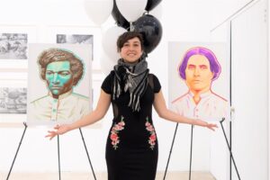 artist Alivia Ruiz standing between two portraits
