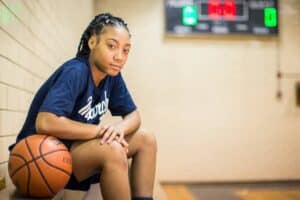 Mo'ne Davis sitting next to a basketball
