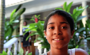 young black filmmaker Zuriel Elise Oduwole in front of plants facing the camera