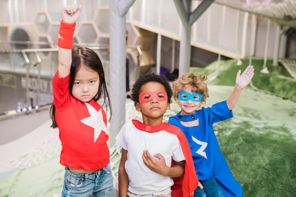 Group of intercultural children in attire of superheroes playing together